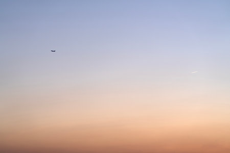 Airplane in the sky at sunset, background with copy space.の写真素材