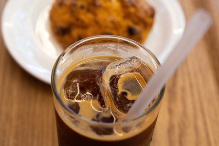 Iced coffee with cookies on wooden table. Close-up.
