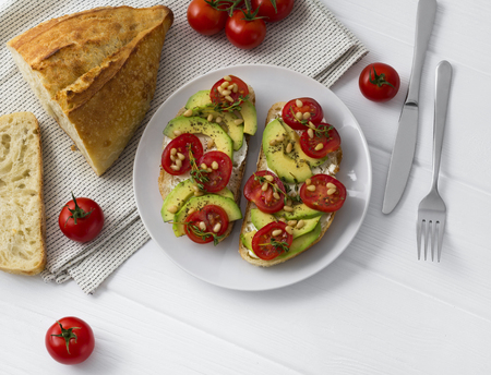 Two sandwiches or tapas prepared with different vegetables,such as avocado, tomato, fresh thyme sparkled with pine nut.の写真素材