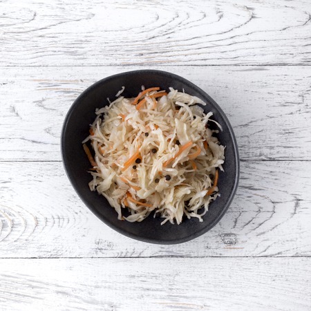 Sauerkraut at white rustic wooden background. Typical fermented food in some countries such as Russia, Poland or German.の写真素材