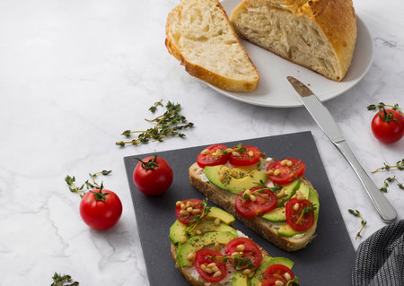 Homemade sandwiches with cream cheese avocado, tomatoes and thyme with olive oil