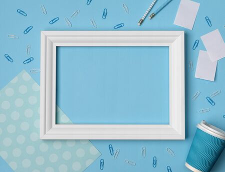 Flat lay empty frame and office supplies on blue pastel backgroundの写真素材