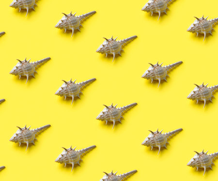 Trendy sunlight summer pattern made with white sea shell on yellow background. Minimal summer...