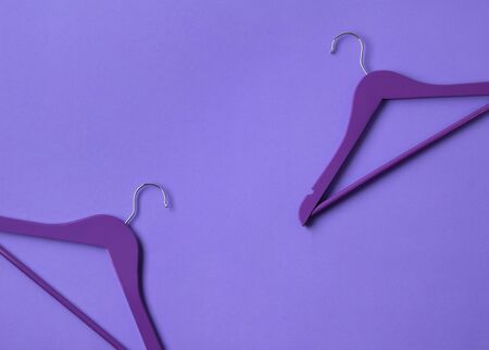 Creative flat lay violet wooden hangers at purple background with copy space. Fashion feminine blog sale store promo design shopping concept. Minimalist style.の写真素材