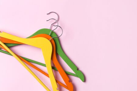 Creative flat lay multicolor wooden hangers at pink pastel background with copy space minimalist style. Template fashion feminine blog sale store promo design shopping conceptの写真素材