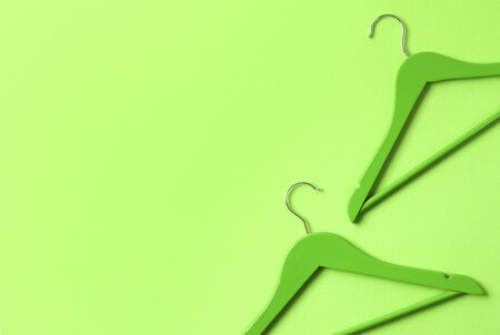 Minimalist top view wooden hangers at green background with copy space. Fashion feminine blog sale store promo design shopping concept.の写真素材