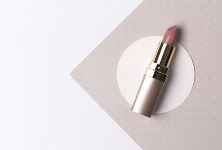 Nude pink lipstick on creative polka dot beige background with copy space. Professional makeup productの写真素材