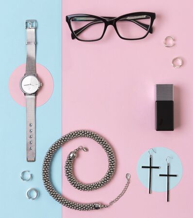 Fashionable female accessories watch, glasses, earrings, perfume, rings and necklace with copy spaceの写真素材