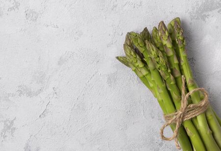 Creative minimal composition of fresh green asparagus on gray concrete background with copy space. Top view flat lay vegan food conceptの写真素材
