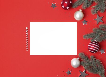 Creative New Year or Christmas greetings letter mockup flat lay top view holiday celebration on red paper background.の写真素材