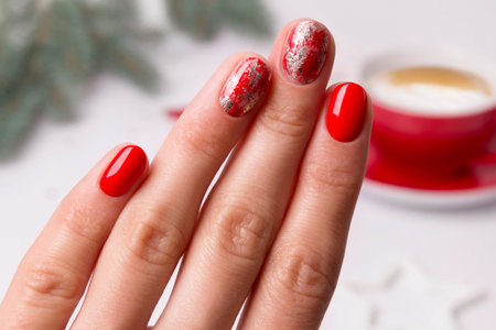 Christmas New Year manicure abstract nail design. Beautiful manicured woman's hand over home office...