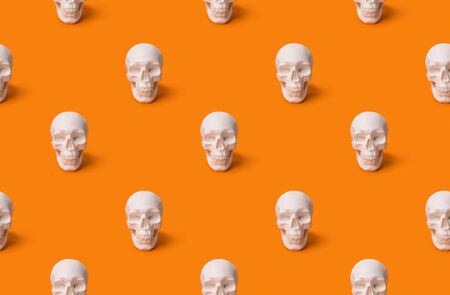 Halloween decorations. Human skull seamless pattern at the orange background with copy space.の写真素材