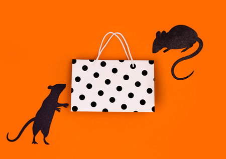 Shopping bag at orange background with silhouettes of miceの写真素材