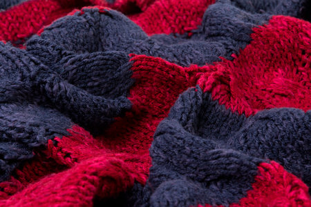 Texture of vinous with blue knitted fabric close up. Wool knitwear. Winter autumn sweater design