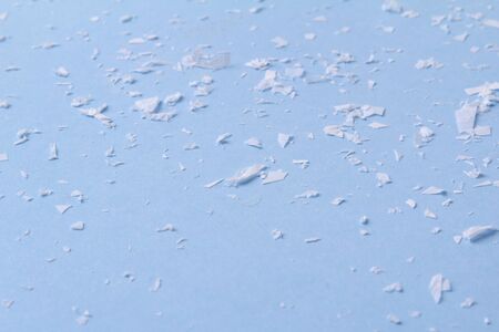 White artificial snow on blue background with copy space. Christmas winter greeting cardの写真素材