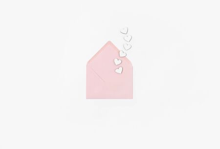 Open envelope with letter and wooden hearts on white background. Valentines Day flat lay top view. Love wedding concept.の写真素材