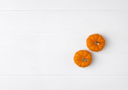 Autumn composition. Pumpkins on white wooden background. Fall halloween concept. Flat lay top view copy spaceの写真素材