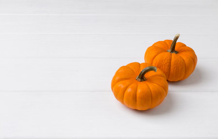 Autumn composition. Pumpkins on white wooden background. Fall halloween concept.