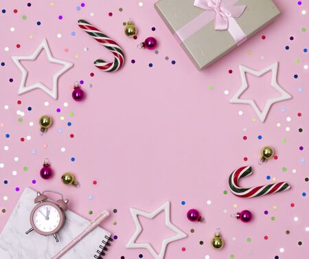 Christmas New year celebration concept. Marble notepad with pen, gift and ornaments on pink background. Flat lay, top viewの写真素材