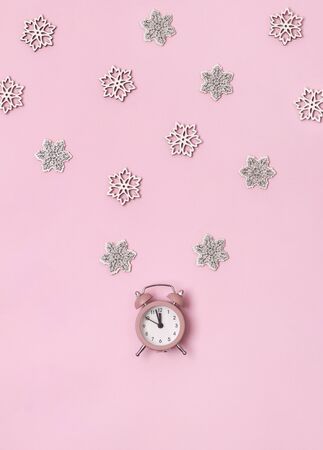 New Year Christmas top view flat lay pink alarm clock with snowflakes copy space background. Feminine template for blog social media or postcardの写真素材