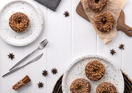 Composition with glazed donuts on a plate on white wooden table. Flat lay top view breakfast conceptの写真素材
