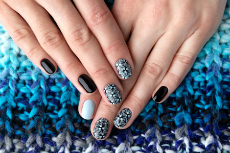 Womans hands with manicure in knitted wool sweater. Winter autumn fashionable blue nail art.の写真素材