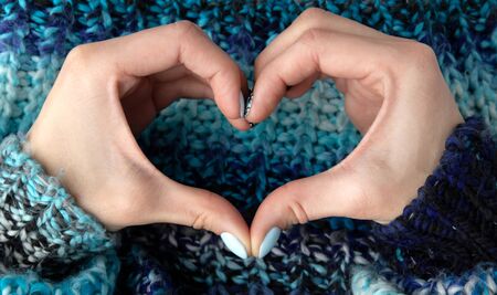 Flat lay top view beautiful young womans hands with manicure in heart shape signの写真素材