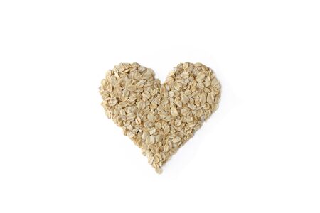 Pile of oatmeal in heart shape isolated on white background. Flat lay top view healty raw food consept.の写真素材