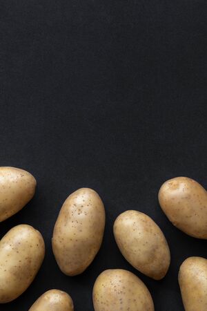 Frame of raw organic potatoes on dark backgroundの写真素材