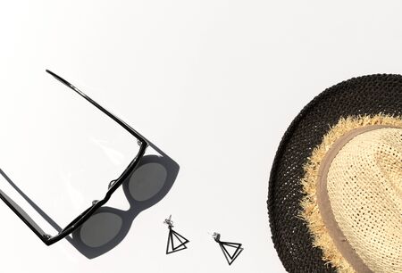 Summer sunlight with trendy sunglasses, earrrings and straw hat on white background. Fashion blogger conceptの写真素材