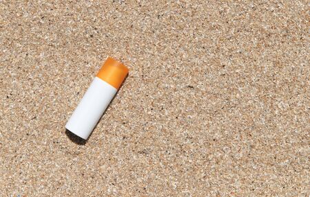 Bottle of sunscreen lotion on the sandy beach by the sea. Health skin care sun protection concept. Cosmetics with natural ingredients.の写真素材