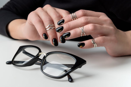 Beautiful womans hand with elegant manicure. Minimal black nail design. Fashionable girl with...