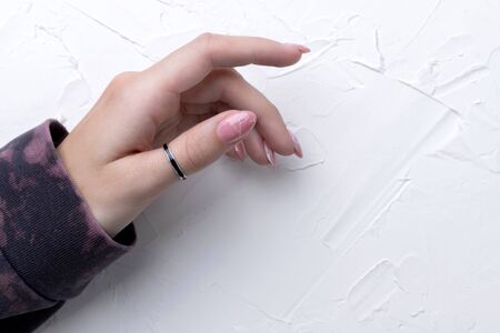 Manicured woman's hand in trendy pink hoodie. Fashionable spring summer nail design. Beauty salon templateの写真素材