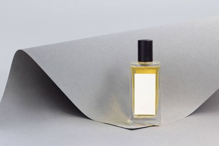 Bottle of essence perfume on grey paper background. Minimal style perfumery branding templateの写真素材
