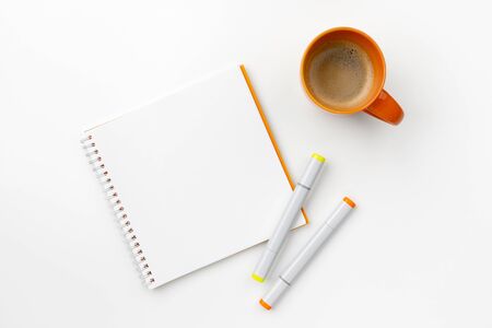 Flat lay top view notepad, markers and coffee cup on white table. Back to school work from home conceptの写真素材
