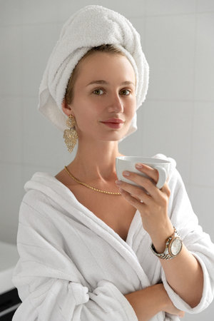 Young woman drink coffee in bathroom. Skin care routine. Slow living stop rushing enjoying life...
