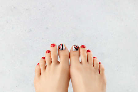 Manicure, pedicure beauty salon concept. Womans feet on gray background.の写真素材