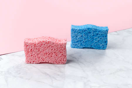 Creative layout with sponges for dishwashing on pink and marble double background. Cleaning service templateの写真素材