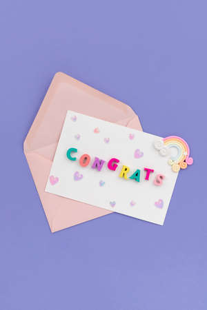 Open pink envelope with the word congrats on violet backgroundの写真素材