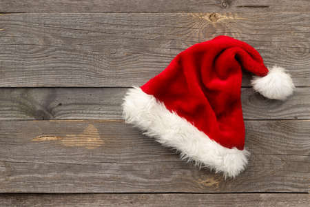 Red Santa hat on old wooden backgroundの写真素材