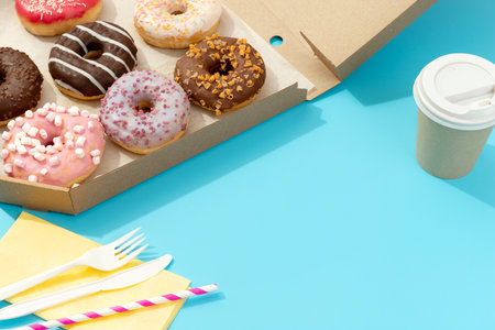 Set of yummy colorful donuts in paper box on blue backgroundの写真素材