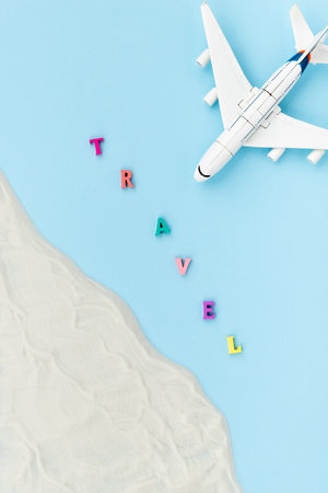 Creative composition with a toy plane, sand and inscription travel.の写真素材