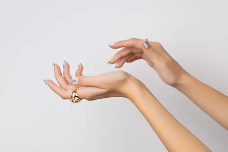 Young adult womans hand with fashionable nails on white background. Spring summer nail design.の写真素材