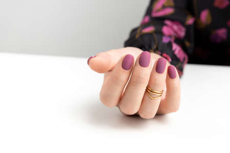 Beautiful womans hands with purple burgundy matte manicureの写真素材