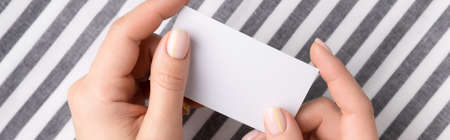 Manicured womans hands holding blank cardの写真素材