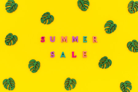 Inscription summer sale in wooden letters on a yellow background.の写真素材