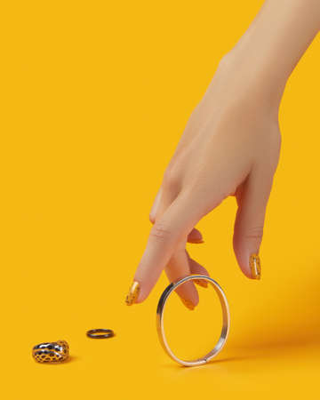 Womans hand with jewelry accessories over orange backgroundの写真素材