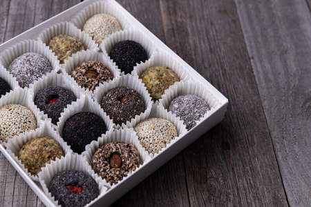 Box of vegan sweets energy balls on wooden tableの写真素材