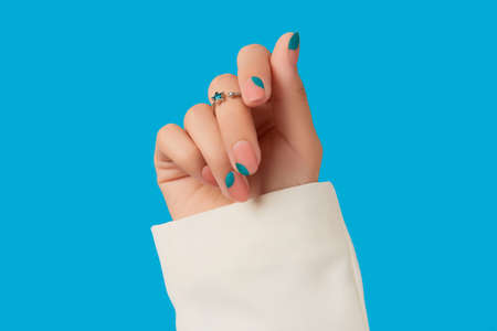Womans hand with blue manicure. Trendy spring summer nail designの写真素材