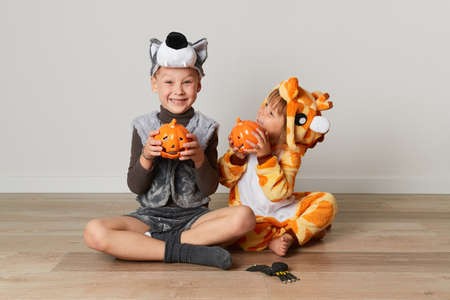 Cute little girl and boy in giraffe and wolf costume play at home. Halloween partyの写真素材